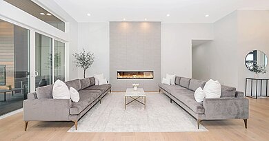 Nowoczesna szara sofa w jasnym, przestronnym salonie
