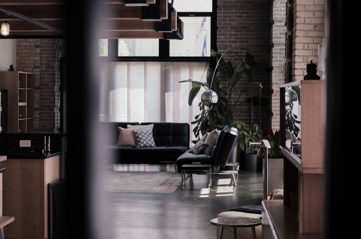 Czarna skórzana sofa z miękkimi poduszkami w stylu Soft Loft