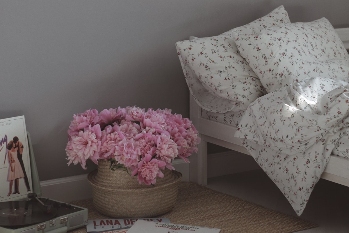 Różowe kwiaty w wiklinowym koszu, dekoracja w stylu shabby chic
